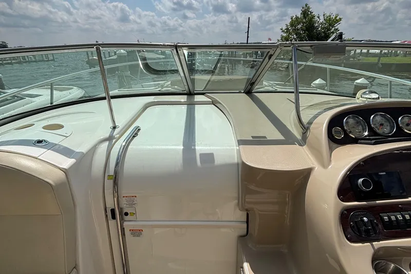 Slide: The Image of 2005 Chaparral Signature 330 boat dashboard with gauges and controls, docked by the water. - 7