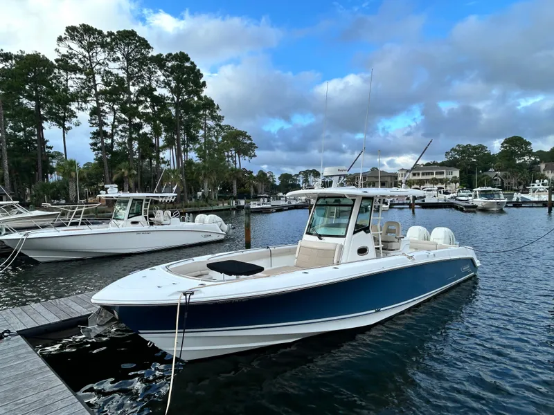 Slide: The Image of 2017 Boston Whaler 330 Outrage docked in a scenic marina setting. - 1