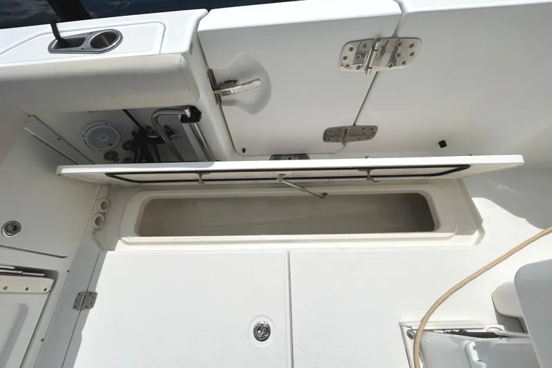Slide: The Image of 2017 Boston Whaler 330 Outrage storage compartment with open hatch and stainless steel hardware. - 28