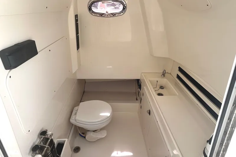 Slide: The Image of 2017 Boston Whaler 330 Outrage cabin interior with toilet and sink. - 29