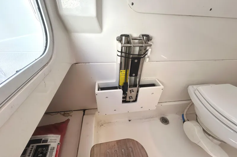 Slide: The Image of Interior of 2017 Boston Whaler 330 Outrage boat, featuring a compact bathroom setup. - 30