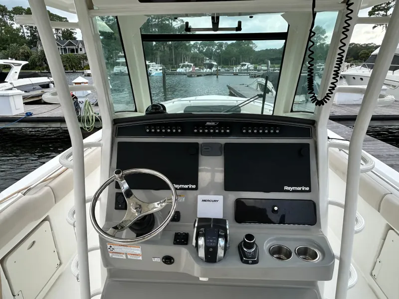 Slide: The Image of 2017 Boston Whaler 330 Outrage helm with Raymarine electronics at marina dock. - 4
