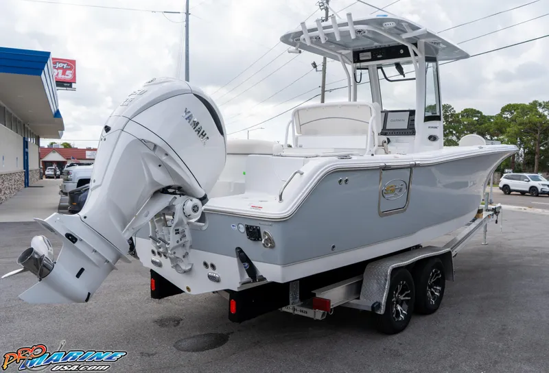 Slide: The Image of 2026 Sea Hunt Ultra 255 SE boat with powerful outboard motor, parked outdoors. - 4