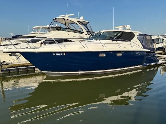 The Image of 2009 Tiara Yachts 4300 Sovran at night, illuminated with red and blue lights. - 0