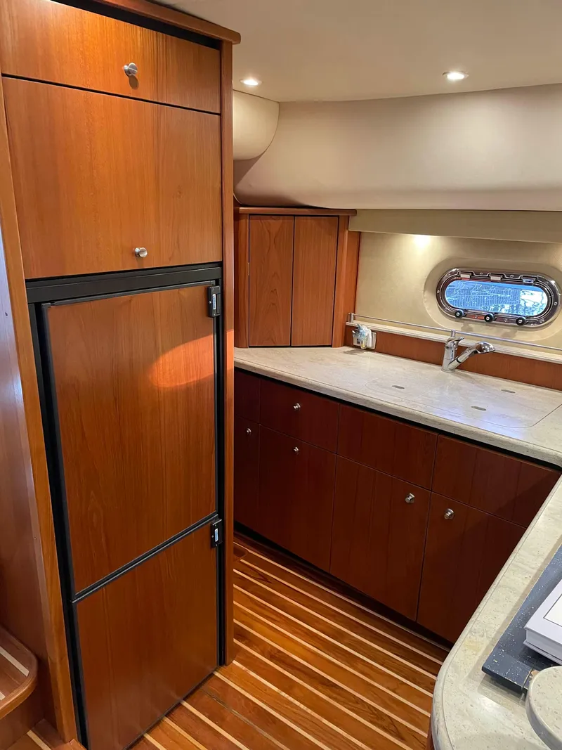 Slide: The Image of 2009 Tiara Yachts 4300 Sovran interior kitchen with wood cabinetry and modern appliances. - 11
