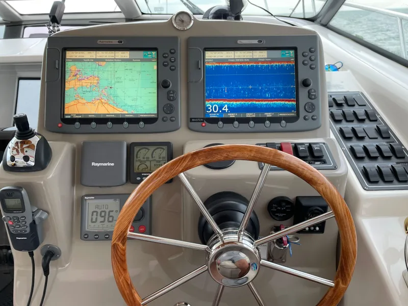 Slide: The Image of Helm of 2009 Tiara Yachts 4300 Sovran with navigation displays and wooden steering wheel. - 4