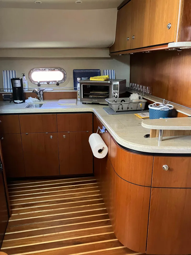 Slide: The Image of 2009 Tiara Yachts 4300 Sovran galley with wood cabinetry and modern appliances. - 8