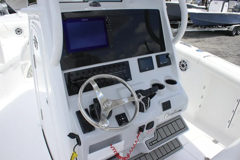 Slide: The Image of 2026 Tidewater 272 LXF boat dashboard with steering wheel and navigation controls. - 23