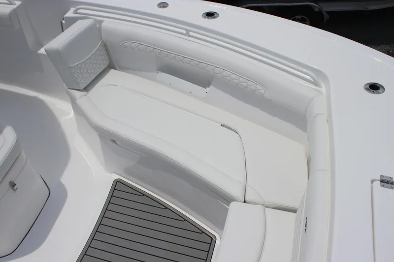 Slide: The Image of 2026 Tidewater 272 LXF boat interior with white cushioned seating and gray flooring. - 9