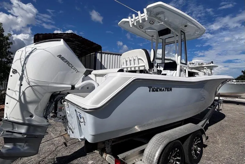 Slide: The Image of 2026 Tidewater 220 CC Adventure boat with Mercury engine on trailer under blue sky. - 3