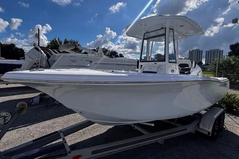 Slide: The Image of 2026 Tidewater 220 CC Adventure boat on trailer under a partly cloudy sky. - 5