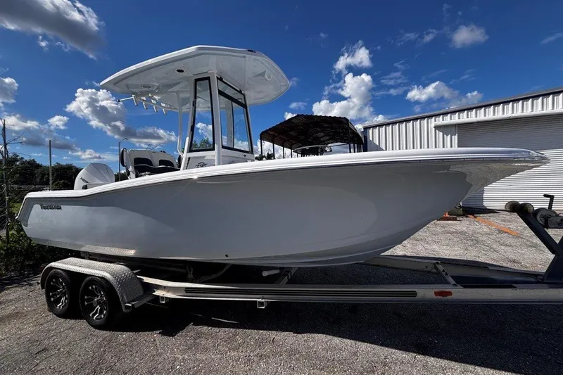 Slide: The Image of 2026 Tidewater 220 CC Adventure boat on trailer under blue sky. - 9