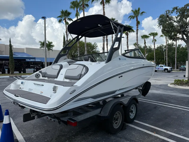 Slide: The Image of 2017 Yamaha Boats 212 Limited S on trailer, parked outdoors with palm trees. - 14