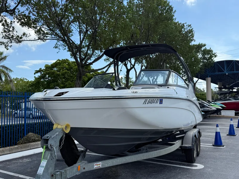 Slide: The Image of 2017 Yamaha Boats 212 Limited S on trailer in parking lot, surrounded by trees. - 3