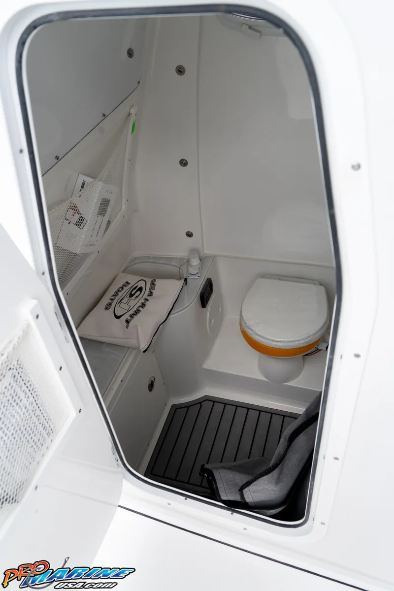 Slide: The Image of 2026 Sea Hunt Gamefish 30 boat interior with compact marine toilet and storage area. - 18