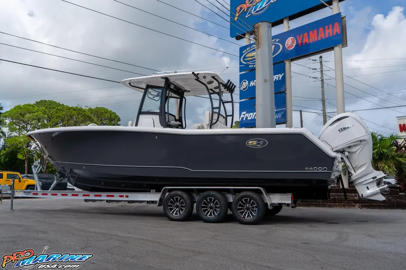 Slide: The Image of 2026 Sea Hunt Gamefish 30 boat on trailer, displayed at dealership with Yamaha signage. - 2