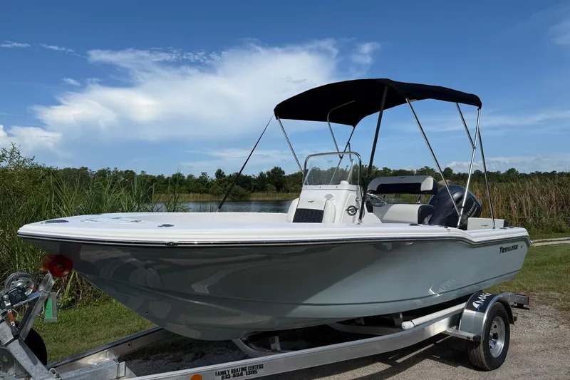 Slide: The Image of 2026 Tidewater 180 CC Adventure boat on trailer, parked near a lake under a blue sky. - 10