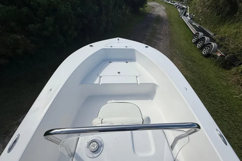 Slide: The Image of 2026 Tidewater 180 CC Adventure boat, white interior, parked on grassy path. - 17