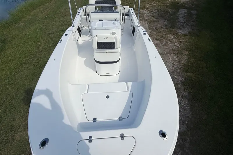 Slide: The Image of 2026 Tidewater 180 CC Adventure boat, white interior, spacious deck, parked on grass. - 18