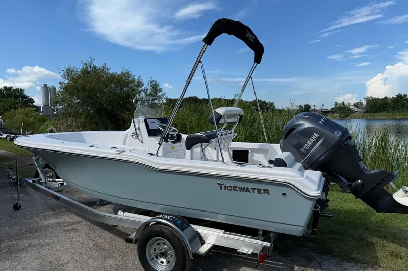 Slide: The Image of 2026 Tidewater 180 CC Adventure boat on trailer by a lake, featuring Yamaha outboard motor. - 2