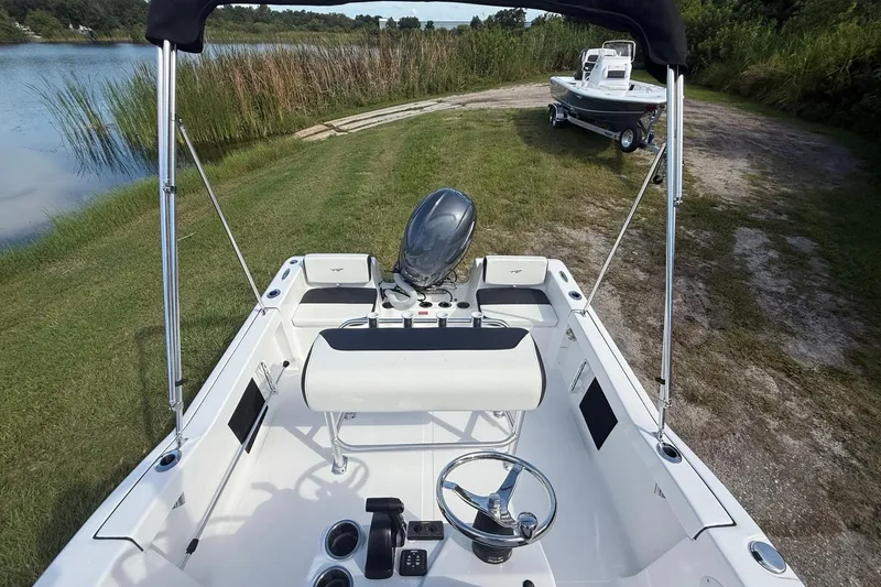 Slide: The Image of 2026 Tidewater 180 CC Adventure boat on grassy shore near a lake. - 21