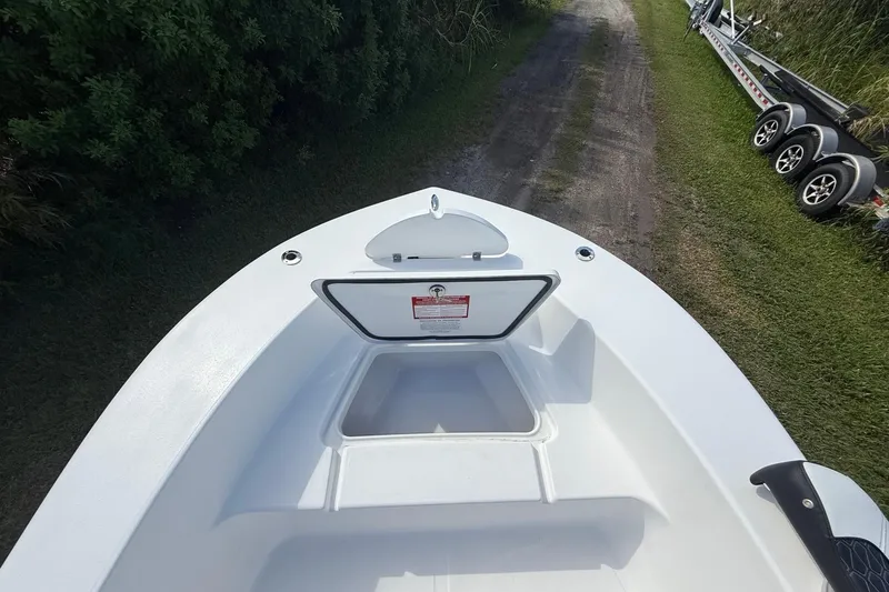 Slide: The Image of 2026 Tidewater 180 CC Adventure boat with open storage compartment on a grassy path. - 30
