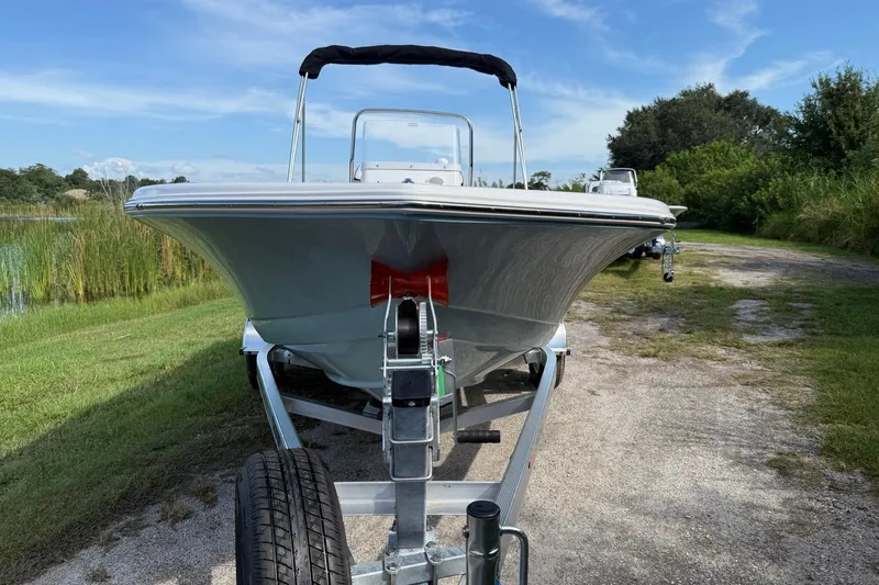 Slide: The Image of 2026 Tidewater 180 CC Adventure boat on trailer, parked near a lake. - 8