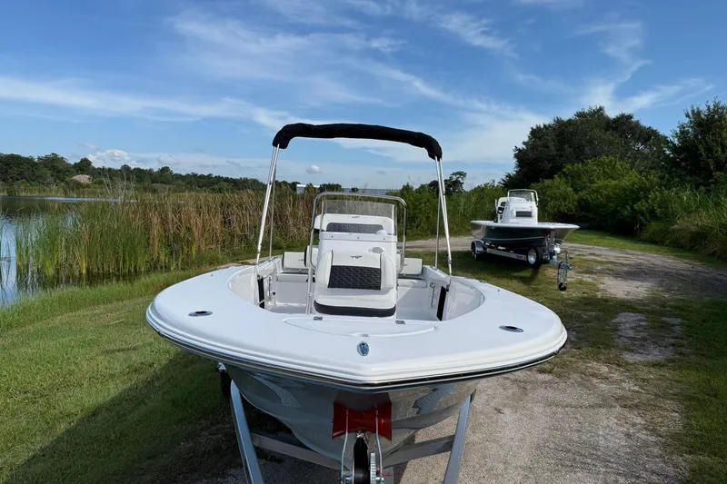 Slide: The Image of 2026 Tidewater 180 CC Adventure boat on trailer by a scenic lake. - 9
