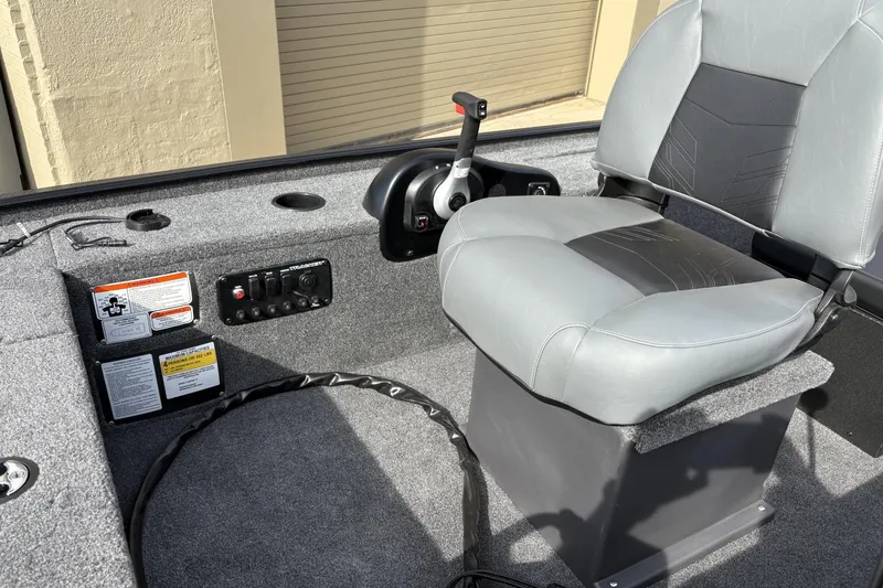 Slide: The Image of 2025 Tracker Panfish 17 boat interior with control panel and cushioned seat. - 2