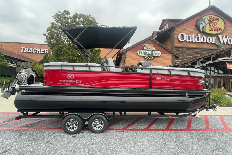The Image of 2025 Regency 230 DL3 pontoon boat displayed outside Bass Pro Shops. - 0