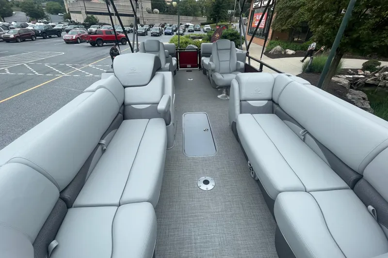 Slide: The Image of 2025 Regency 230 DL3 pontoon boat with Mercury engine at outdoor store parking lot. - 2