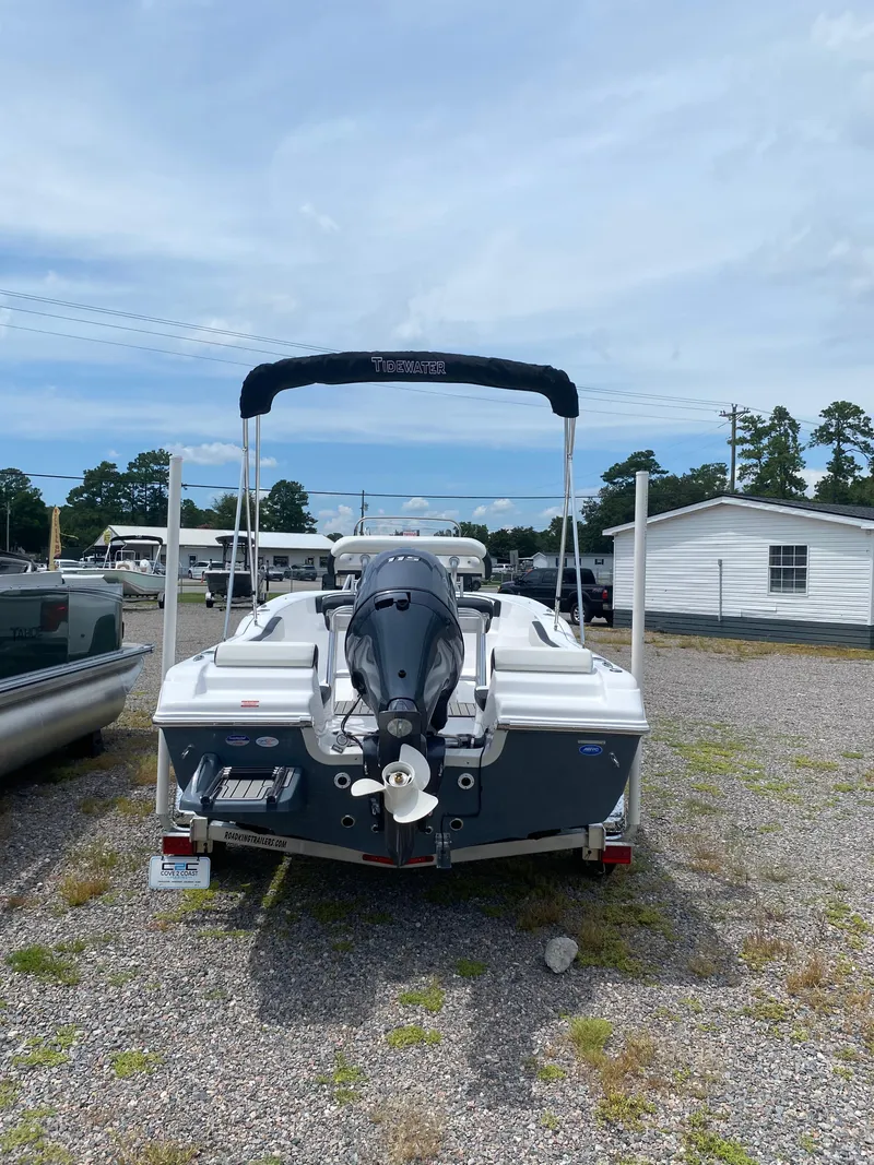 Slide: The Image of 2026 Tidewater 180 CC Adventure boat with outboard motor, parked on gravel lot. - 13
