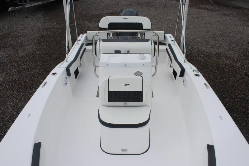 Slide: The Image of 2026 Tidewater 180 CC Adventure boat interior with seating and console, on gravel surface. - 19