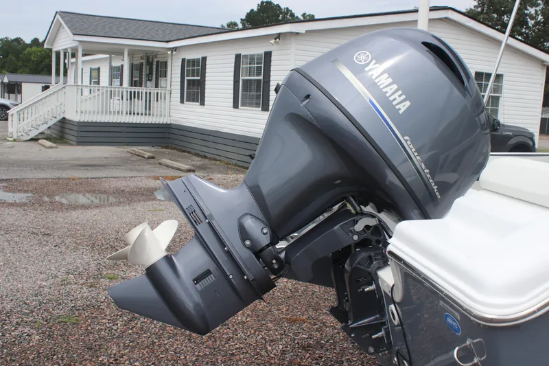 Slide: The Image of Yamaha outboard motor on 2026 Tidewater 180 CC Adventure boat, parked near a house. - 21