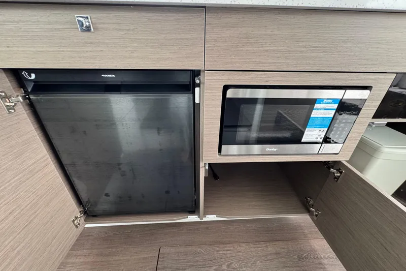 Slide: The Image of 2026 Jeanneau NC 1095 cabin interior with bed and wooden cabinetry. - 12