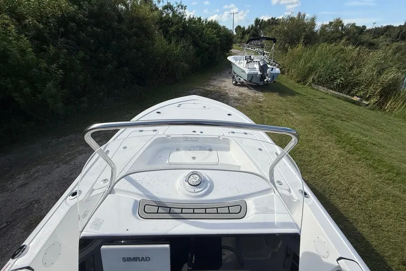 Slide: The Image of 2026 Tidewater 2110 Bay Max boat on grassy path, surrounded by lush greenery. - 16