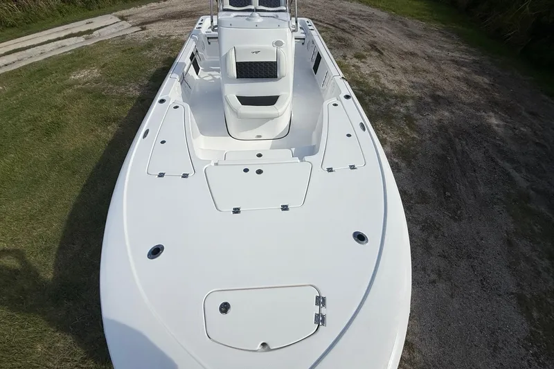 Slide: The Image of 2026 Tidewater 2110 Bay Max boat on grassy terrain, showcasing deck layout. - 18