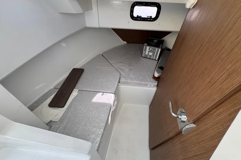 Slide: The Image of 2026 Jeanneau NC Sport 795 Series 2 cabin interior with wooden door and cushioned seating. - 14
