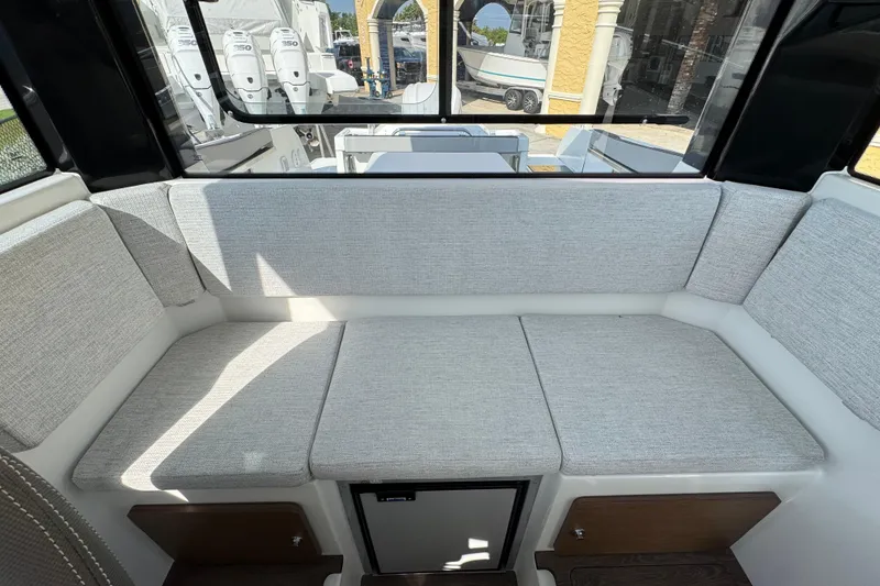 Slide: The Image of 2026 Jeanneau NC Sport 795 Series 2 interior with cushioned seating and window view. - 21
