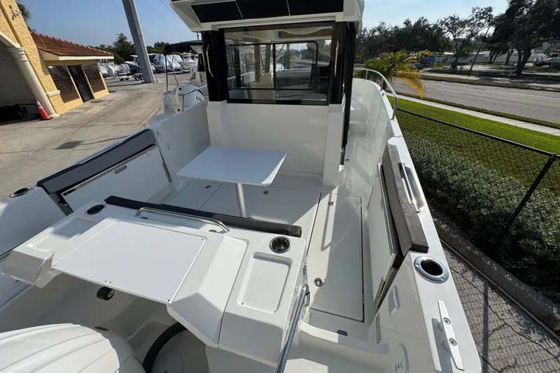 Slide: The Image of 2026 Jeanneau NC Sport 795 Series 2 boat deck with seating and table, docked outdoors. - 4