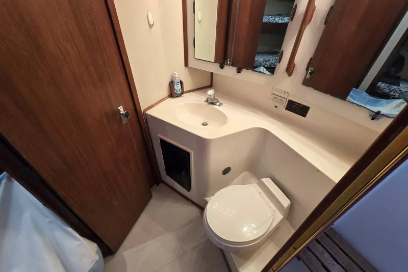 Slide: The Image of Bathroom interior of 1988 Topaz 44 Flybridge yacht with sink, toilet, and mirror. - 14
