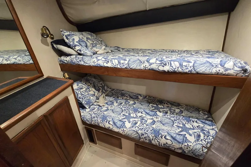 Slide: The Image of Bunk beds with nautical-themed bedding in a 1988 Topaz 44 Flybridge cabin. - 15
