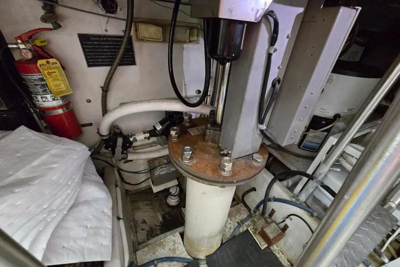 Slide: The Image of Engine room of 1988 Topaz 44 Flybridge with hydraulic components and fire extinguisher. - 29
