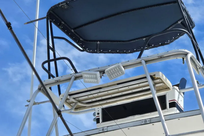 Slide: The Image of Flybridge of 1988 Topaz 44 boat with canopy and lights against blue sky. - 33