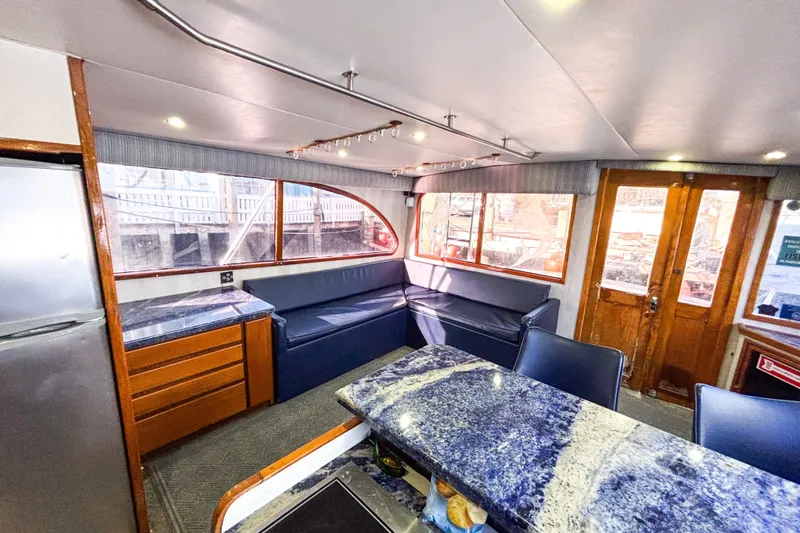 Slide: The Image of Luxurious interior of 1988 Topaz 44 Flybridge yacht with blue seating and wooden accents. - 38