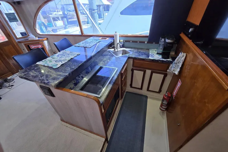 Slide: The Image of Interior of 1988 Topaz 44 Flybridge yacht featuring a compact kitchen area. - 43