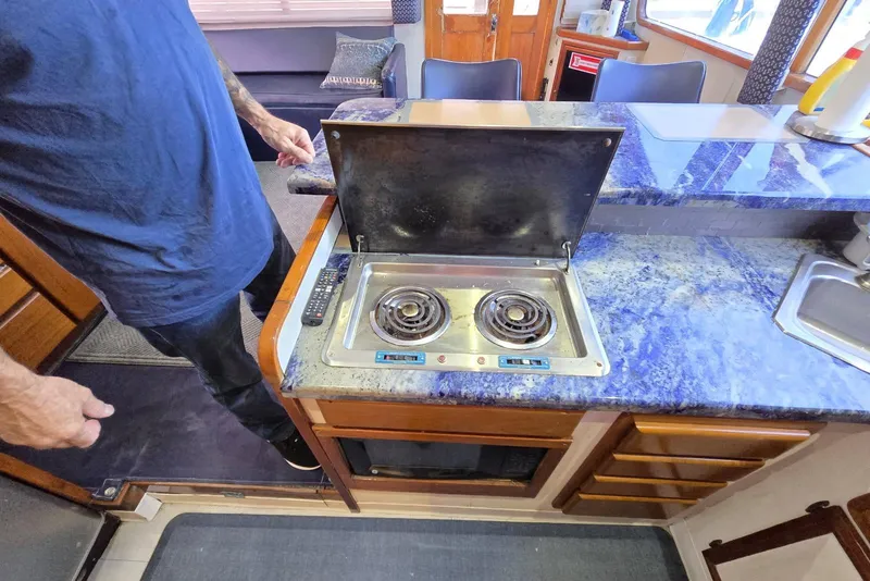 Slide: The Image of 1988 Topaz 44 Flybridge yacht kitchen with electric stove and blue countertop. - 6