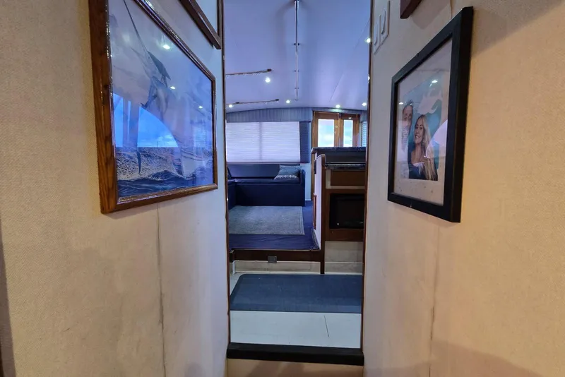 Slide: The Image of Interior hallway of 1988 Topaz 44 Flybridge yacht with framed photos on walls. - 9