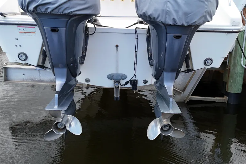 Slide: The Image of 2007 Pursuit OS 335 Offshore boat with Yamaha engines and rod holders, docked by a railing. - 13