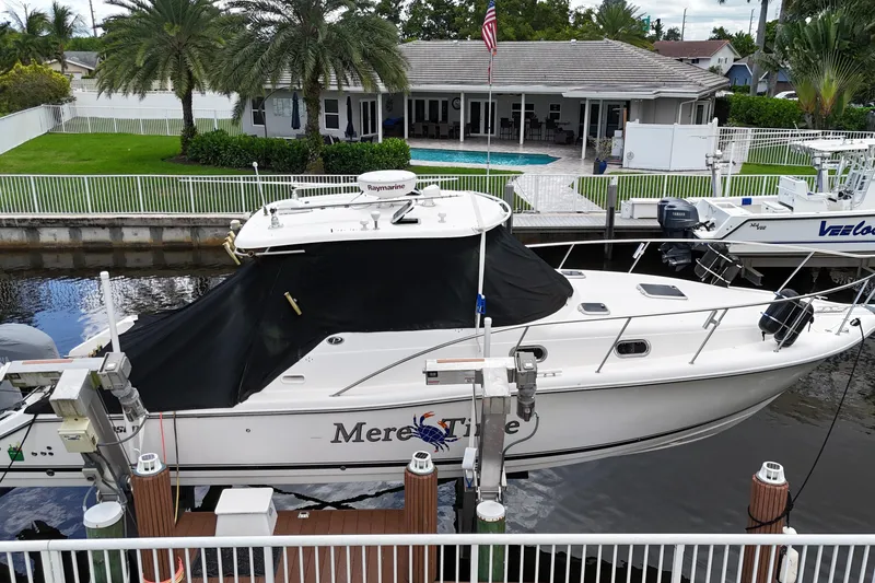 Slide: The Image of 2007 Pursuit OS 335 Offshore boat docked at marina with industrial background. - 2